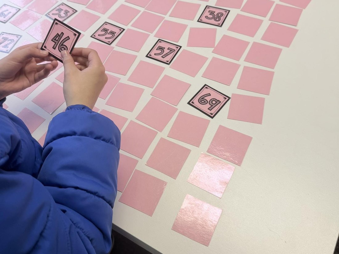 A student matching numbered cards during a math game at the CoreLogic Learning work table