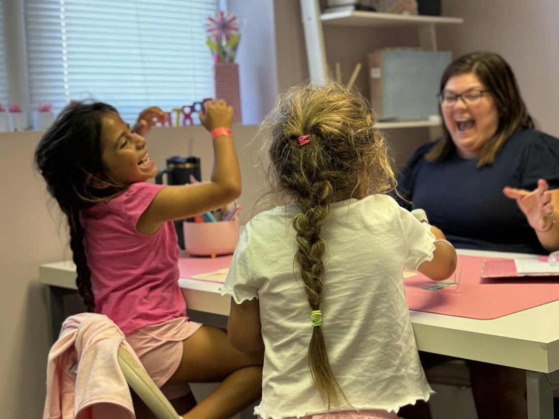 Miss Tiffany laughing with two students during a session at CoreLogic Learning in Battle Creek